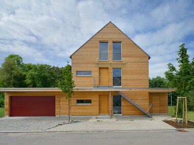 Frontansicht des Bauprojekt Erstling als Mehrgenerationenhaus mit Holzfassade